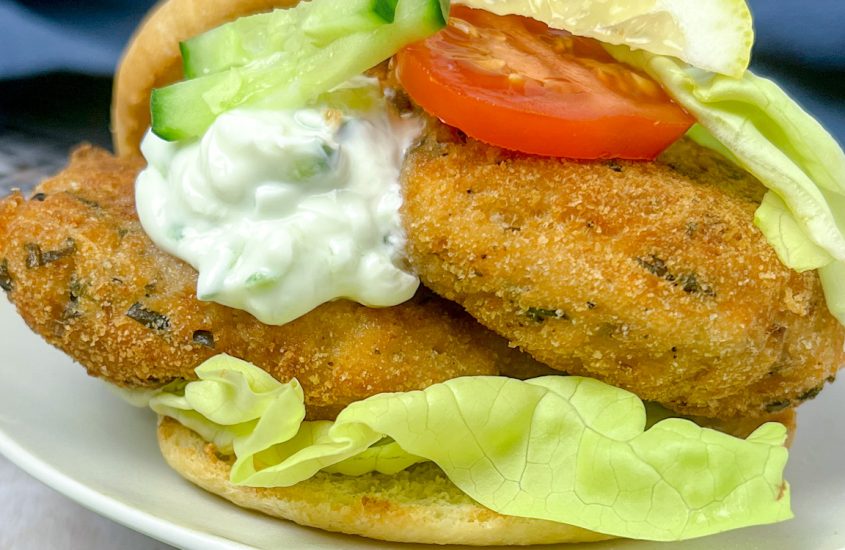 Fisch-Burger mit Tzatziki, Gurken, Tomaten & Salat